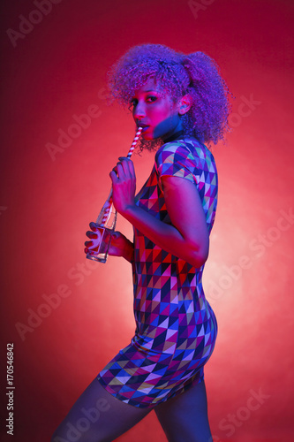 isolated woman holding a vintage refreshment with a straw and neon lights
