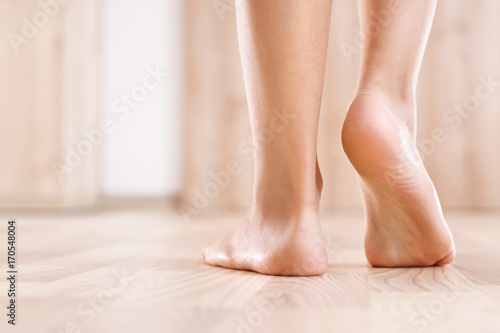Płaskostopie. Zdrowa stopa dziecka.   Stopy  bosego dziecka na tle drewnianej podłogi   © Robert Przybysz