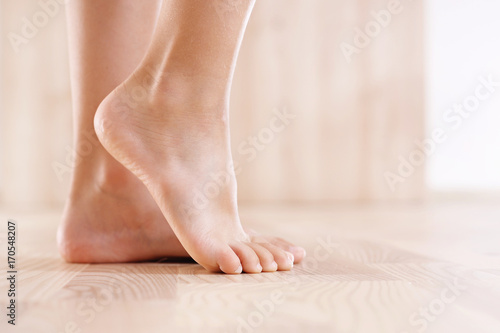 Zdrowa stopa dziecka. Stopy bosego dziecka na tle drewnianej podłogi