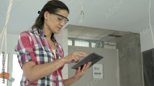 Woman wearing goggles and browsing internet on tablet in the new apartment, steadycam shot
