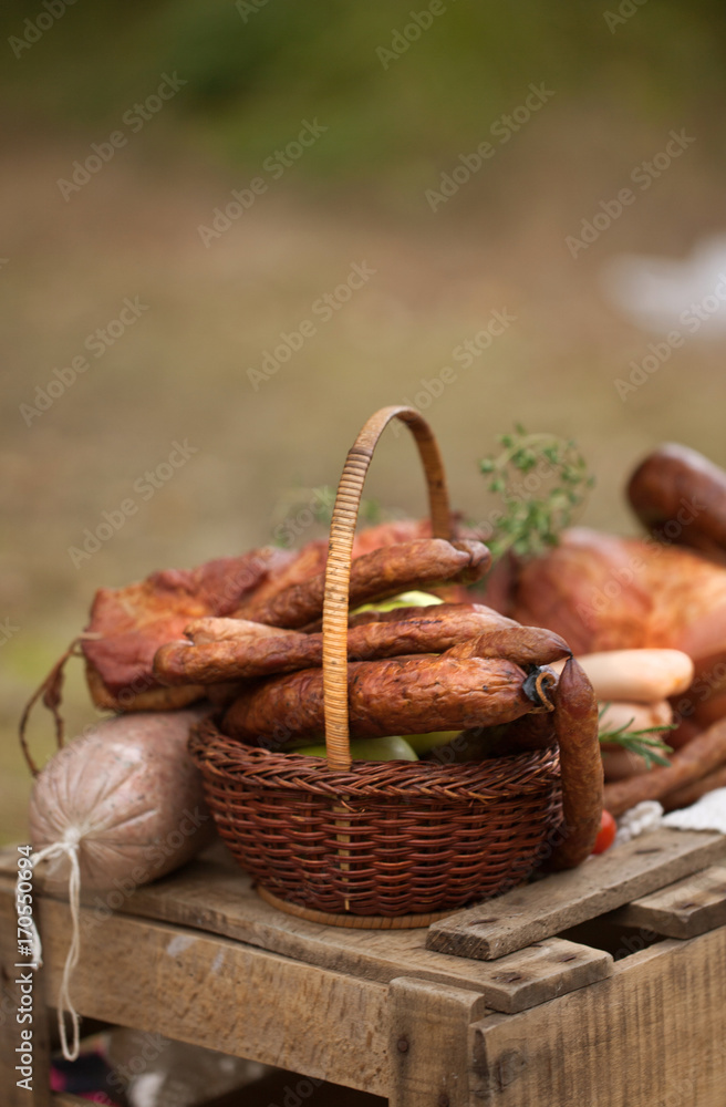 picnic - cured meat, sausages in a basket on the blanket picnic - cured meat, sausages in a basket on the blanket