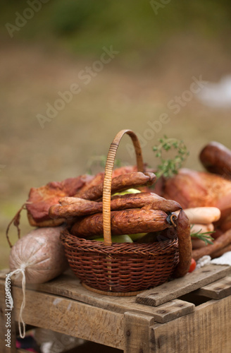 picnic - cured meat  sausages in a basket on the blanket