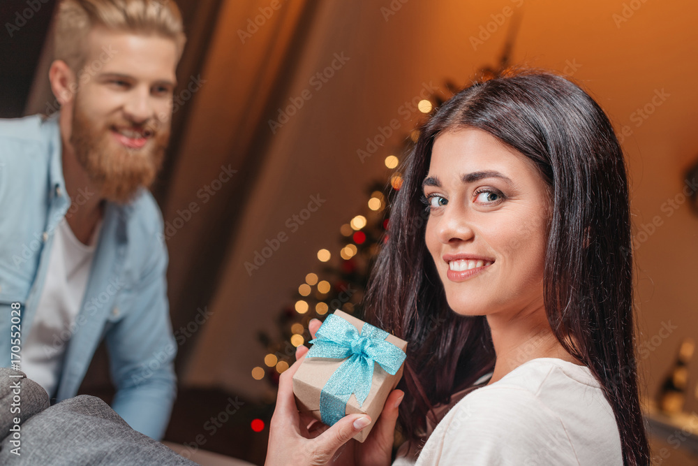 man presenting christmas gift to girlfriend man presenting christmas gift to girlfriend