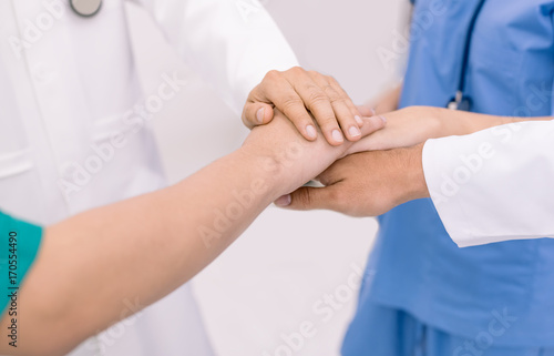 Doctors and nurses in a medical team stacking hands,teamwork medical concept © kittipong