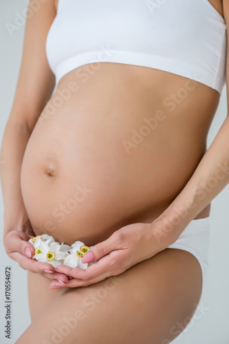 belly of pregnant woman with flowers