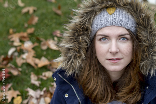 Portrait of a young woman wearing hood in autumn. Soft focus © demimerzie