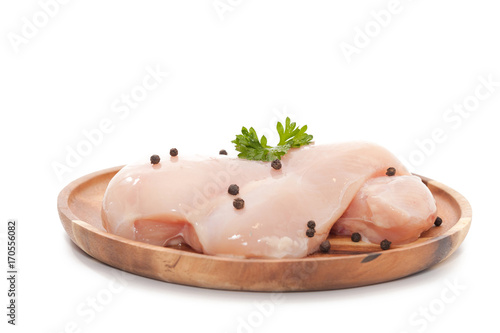 Raw chicken breast,peppers and parsley on wooden plate