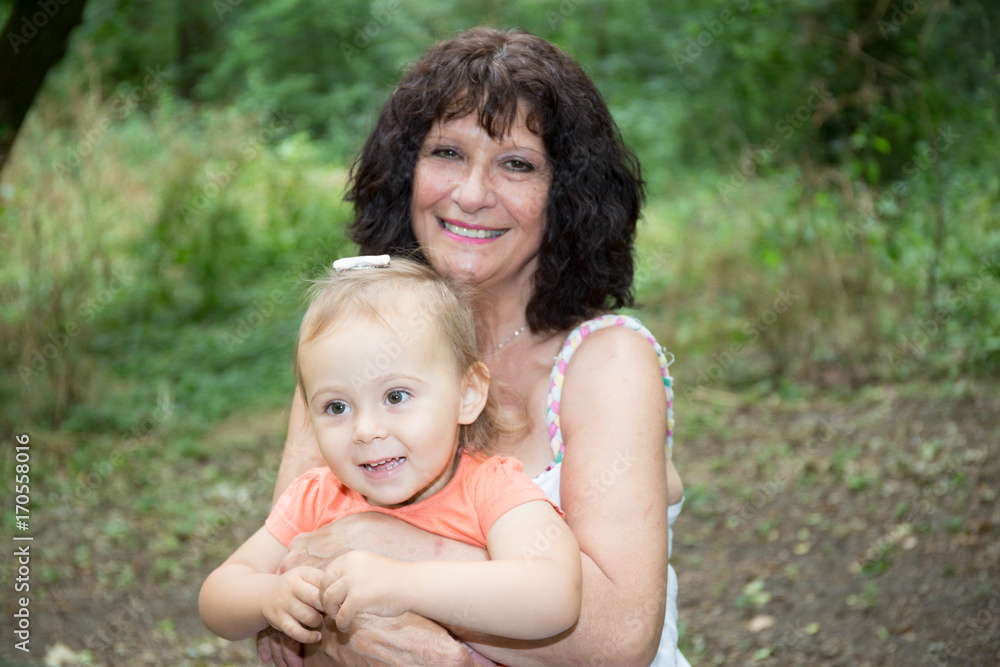 grandmother with granddaughter in knees in summer park grandmother with granddaughter in knees in summer park