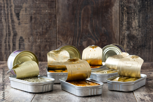 Cans of preserves on wooden table.  photo