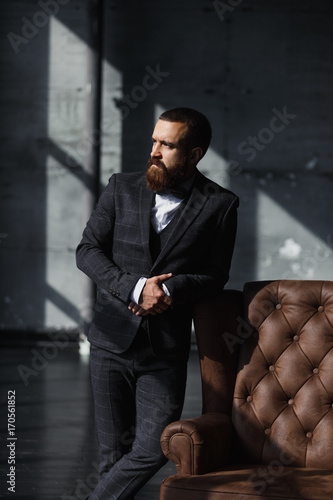 Bilde på lerret Bearded young businessman standing on modern loft office