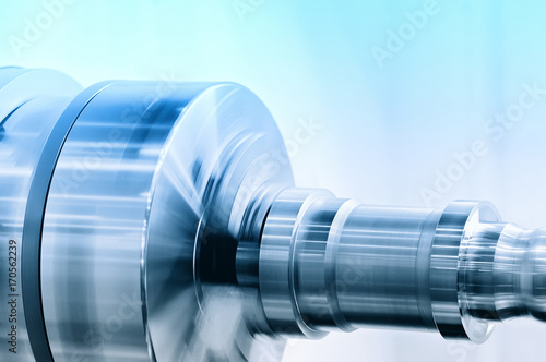 Rotating spindle of turning lathe and metal detail. Selective blue toning. 