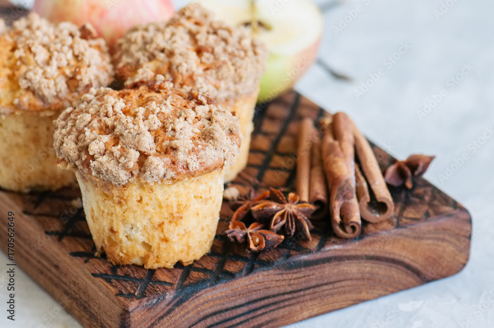 Fototapeta premium Apple cinnamon crumble muffins on a wooden board. White stone background. Close up and copy space.