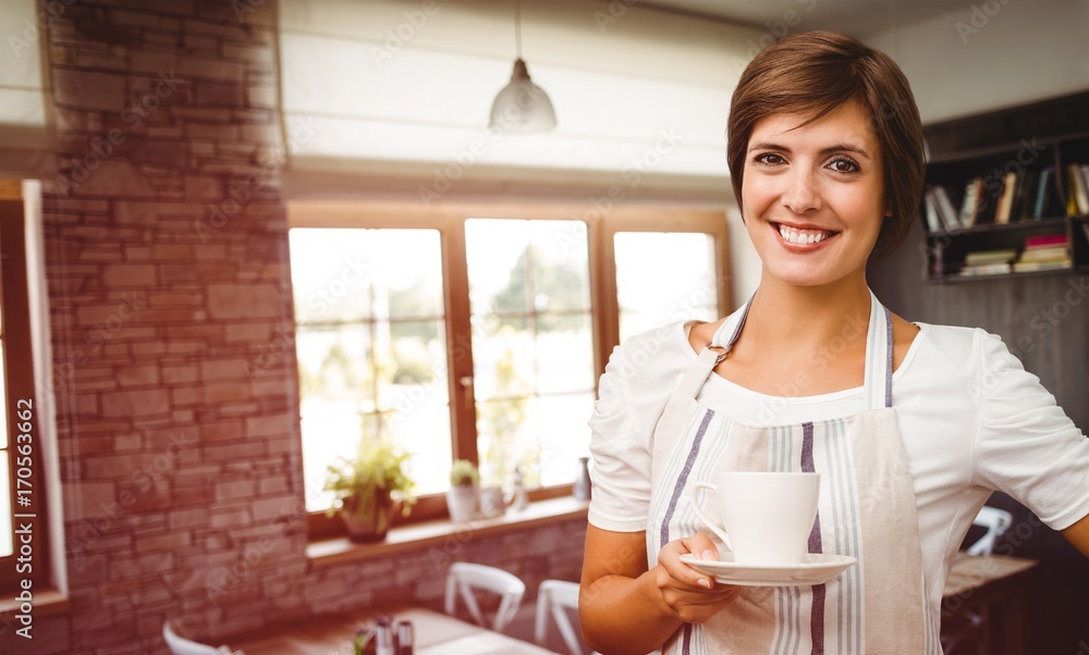 Composite image of smiling waitress holding a cup of coffee Composite image of smiling waitress holding a cup of coffee