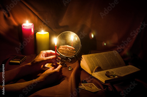 Fortune telling with a mirror and candles on a dark night photo