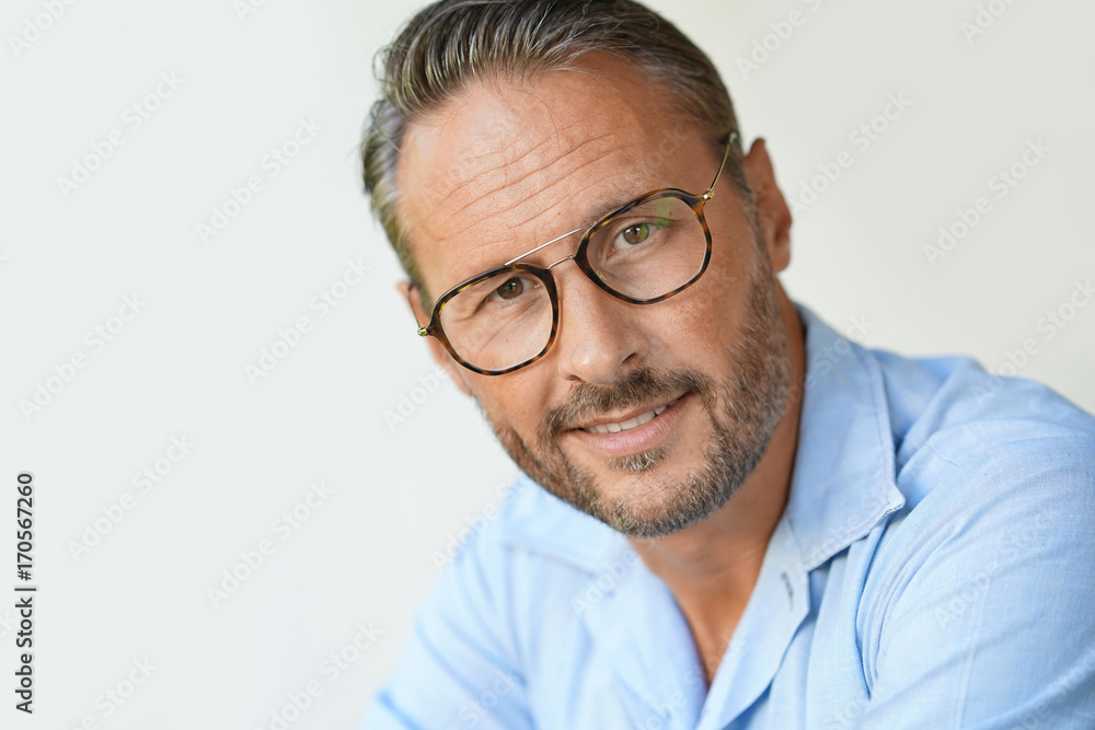 Portrait of mature man with eyeglasses and blue shirt, isolated Portrait of mature man with eyeglasses and blue shirt, isolated
