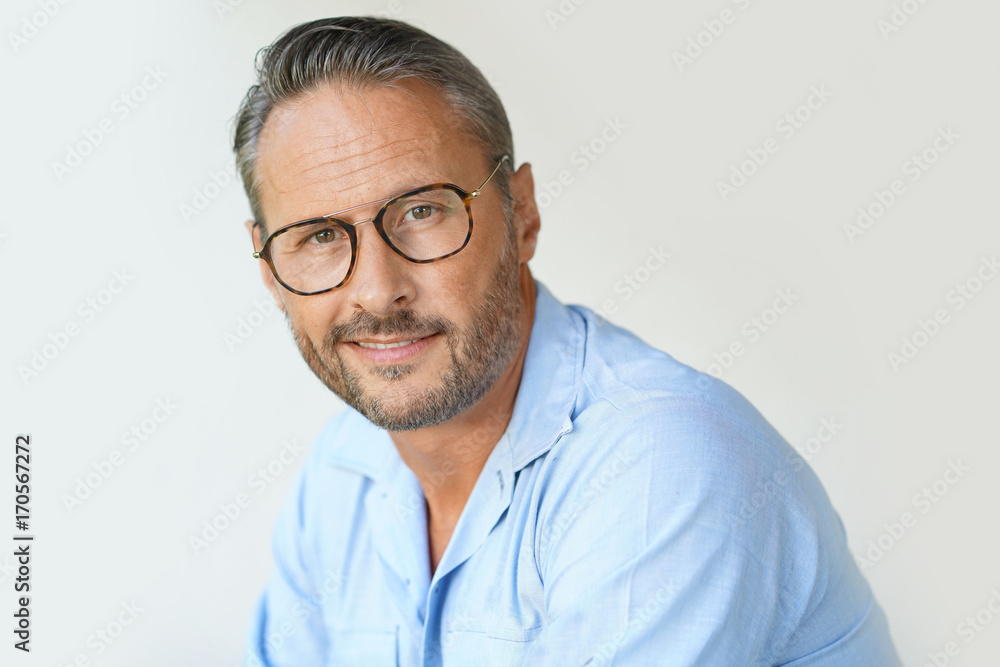 Portrait of mature man with eyeglasses and blue shirt, isolated Portrait of mature man with eyeglasses and blue shirt, isolated