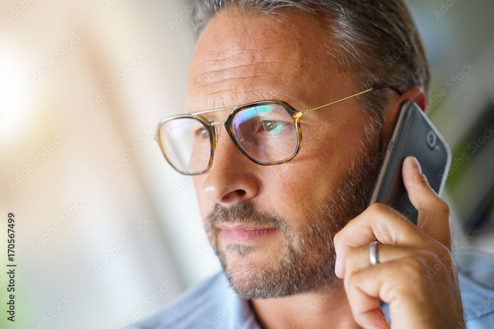 Closeup of mature man holding smartphone to ear