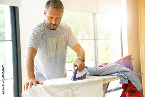 Man at home ironing clothes