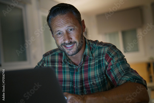Man at home working late on laptop computer at night