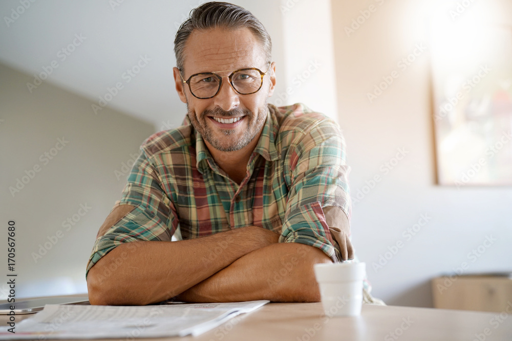 Handsome mature man at home reading newspaper Handsome mature man at home reading newspaper