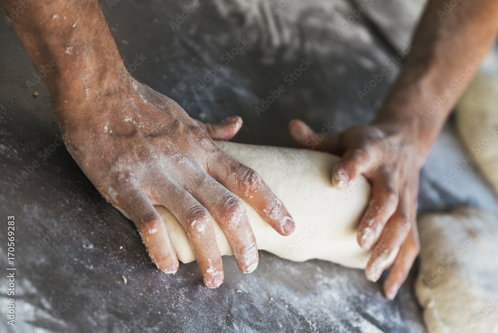 Baker preparing bread. Close up of hands kneading dough.