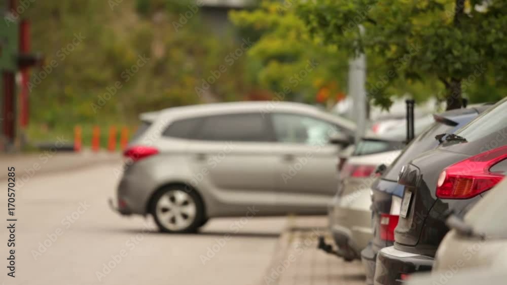 A row of vehicles. One car leaves parking. A row of vehicles. One car leaves parking.