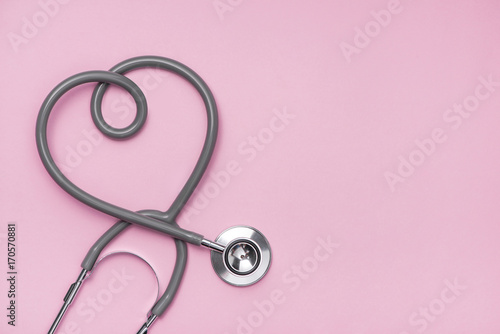 Medical concept. The stethoscope with heart shape on pink background. photo