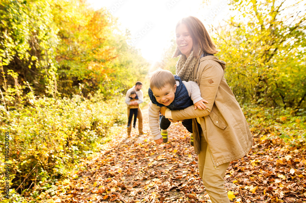 Beautiful young family on a walk in autumn forest. Beautiful young family on a walk in autumn forest.