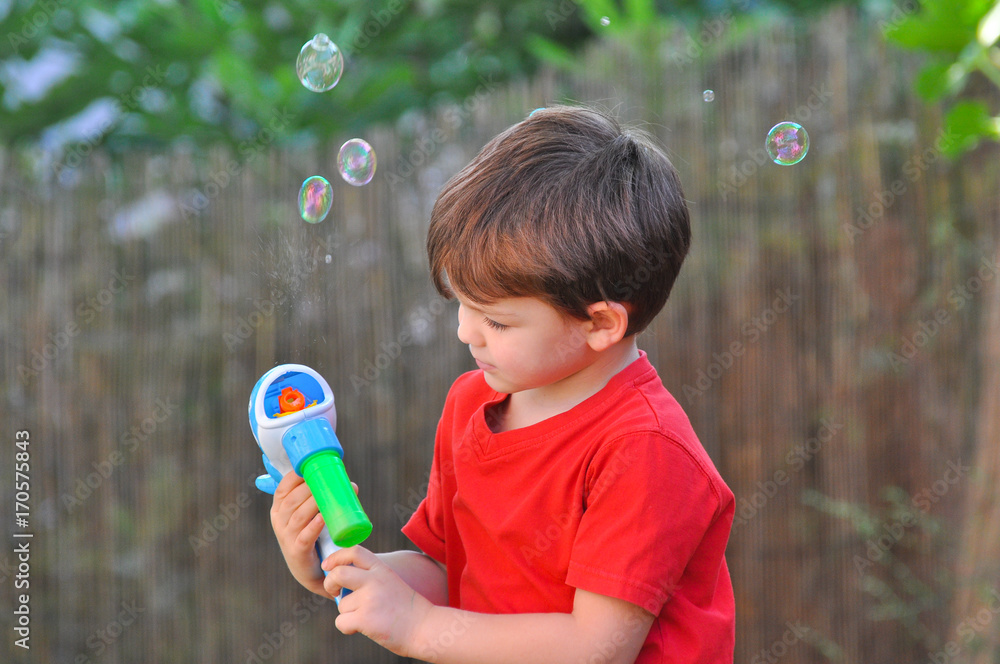 Boy make a soap bubbles. Boy play in the yard with soap bubbles Boy make a soap bubbles. Boy play in the yard with soap bubbles