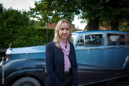 blonde girl in front of classic car