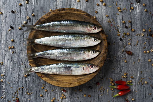raw sardines on a rustic wooden table photo