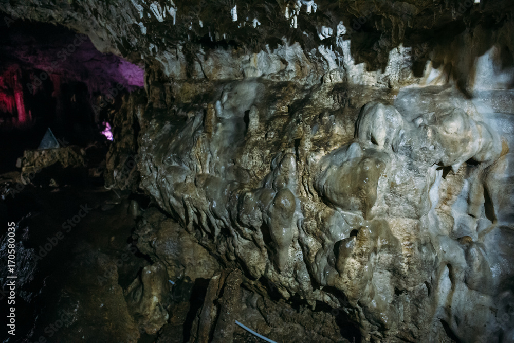 Fototapeta premium Stone wall with outgrowths inside the underground cave