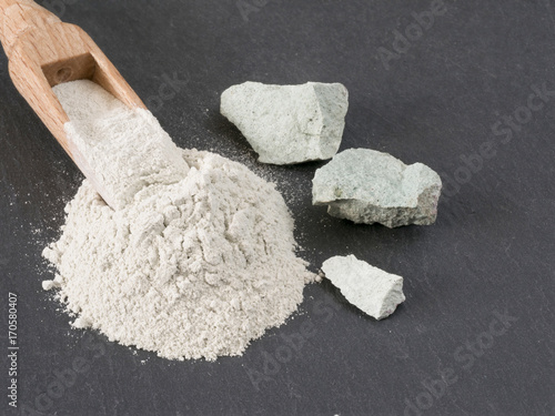 Zeolite natural  raw stones and powder on black stone  background.