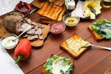 the hostess prepares a sandwich on a wooden table for guests