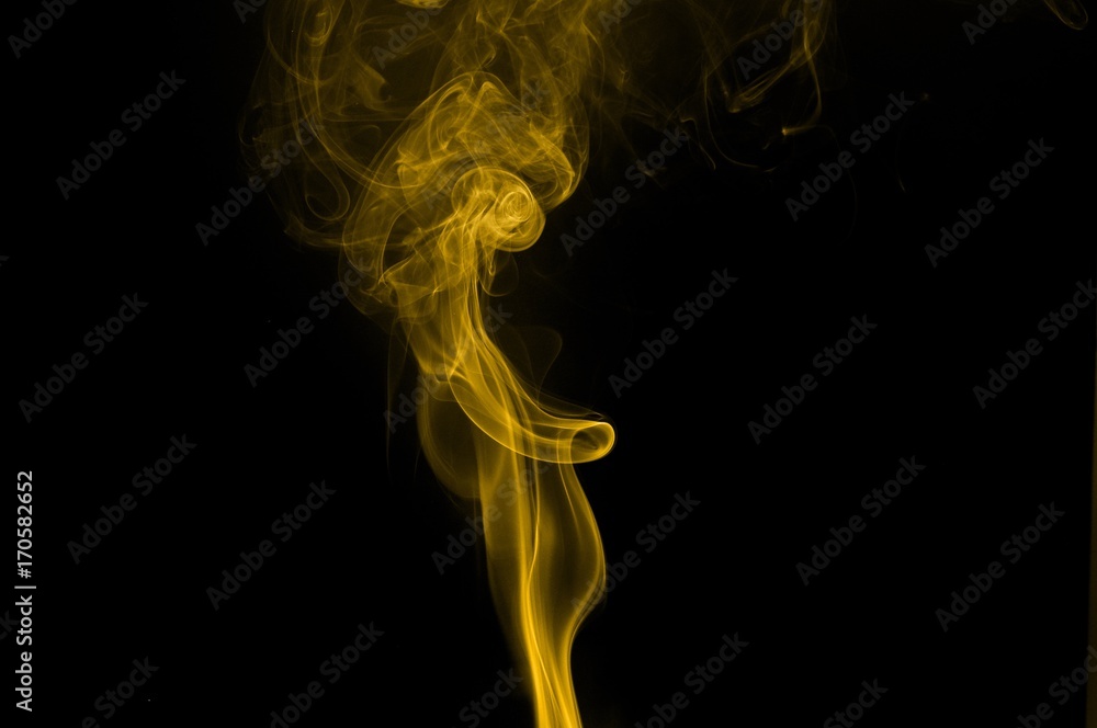 Obraz premium Gold smoke on black background,movement of gold smoke, Abstract gold smoke on black background, gold background,gold ink background,yellow smoke,Glittering gold smoke tail