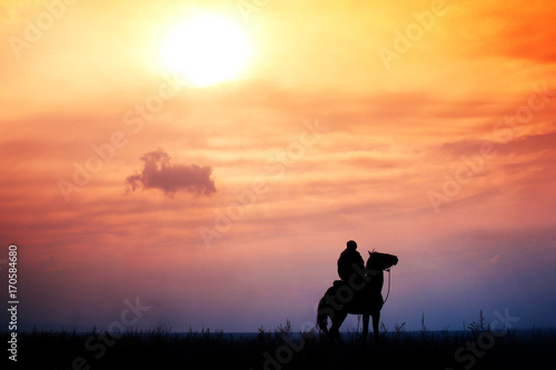 rider on horseback in a steppe during colorful sunset, Kazakhstan
