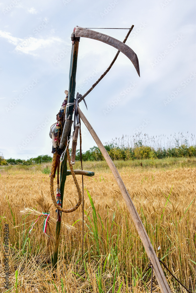Naklejka premium retro harvesting tools hanging on a sickle