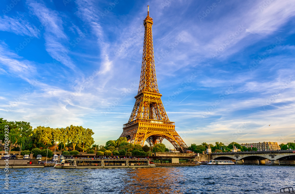 Naklejka premium Paryska wieża eifla i rzeczny wonton przy zmierzchem w Paryż, Francja. Wieża Eiffla jest jednym z najbardziej znanych zabytków Paryża.