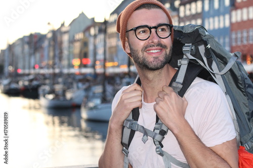 Backpacker smiling in the epic Nyhavn, Copenhagen, Denmark.