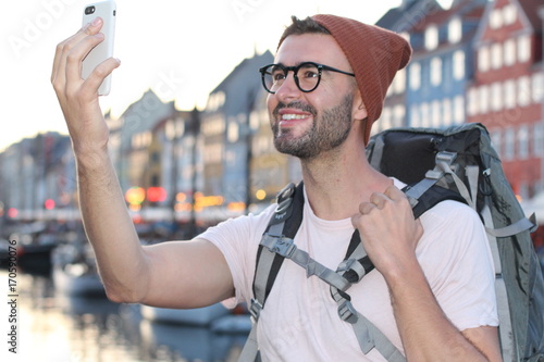 Hip male taking a selfie in Nyhavn, Copenhagen (Denmark) photo