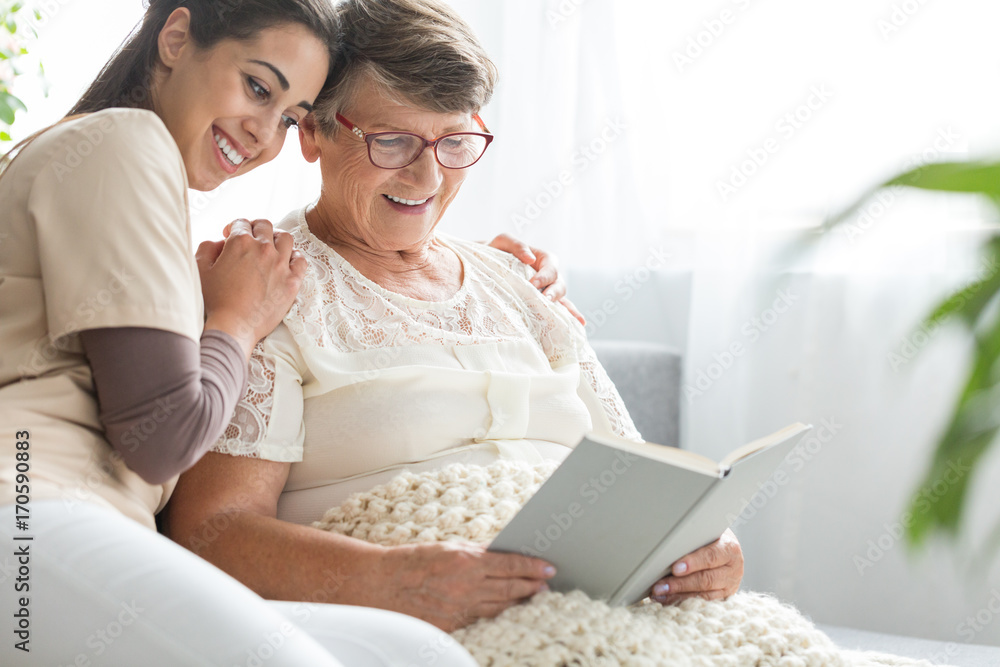 Woman reading book to granddaughter Woman reading book to granddaughter