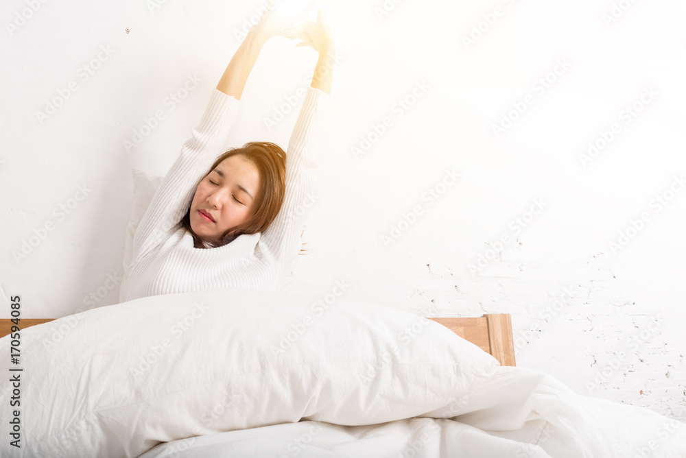 Woman stretching in bed after wake up in the morning at home Woman stretching in bed after wake up in the morning at home