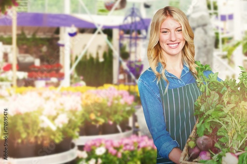 Composite image of portrait of young woman holding vegetables in