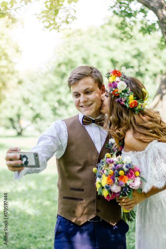 Young couple - bride and groom making selfie during wedding ceremony.