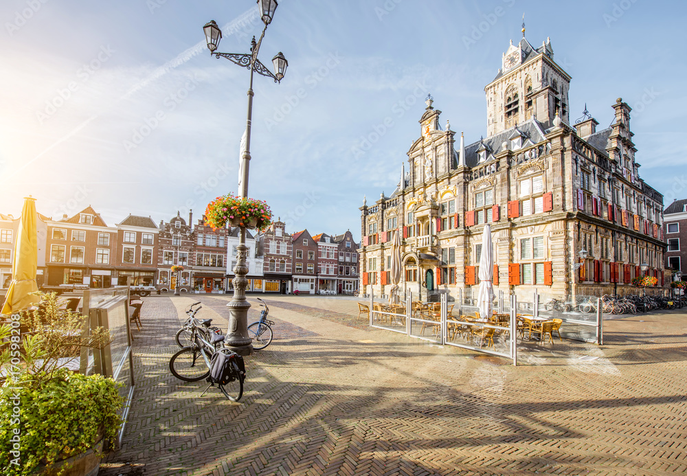 Fototapeta premium View on the Town hall and beautiful buildings on the central square during the sunny morning in Delft city, Netherland