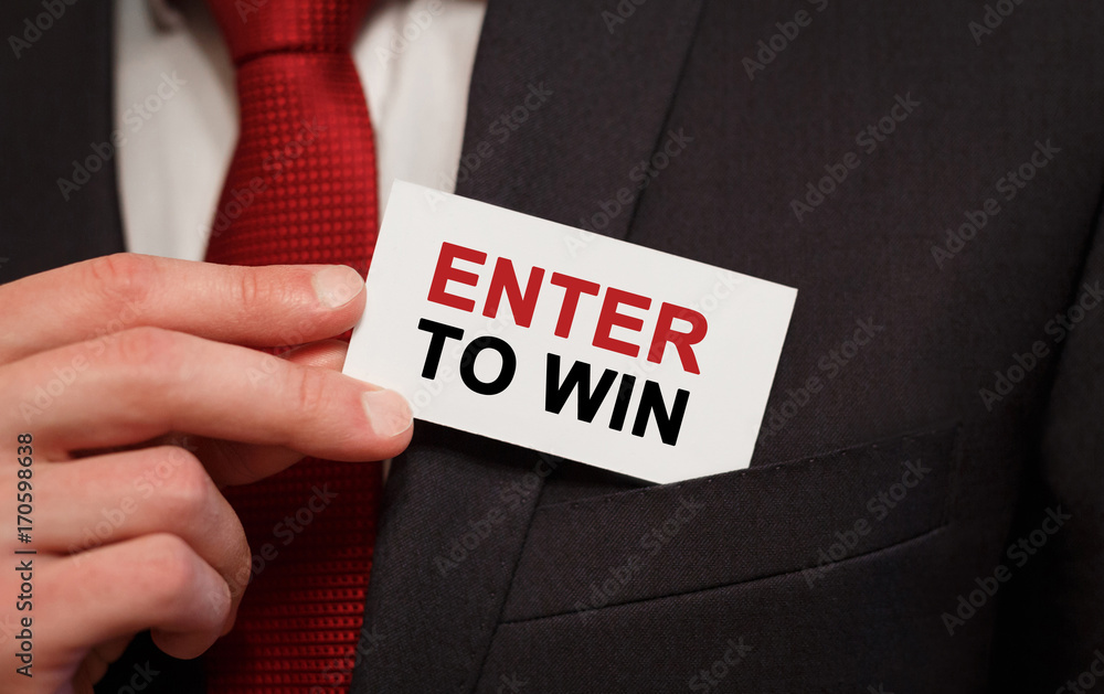 Businessman putting a card with text Enter to Win in the pocket Businessman putting a card with text Enter to Win in the pocket
