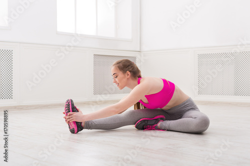 Fitness woman stretching at white background indoors