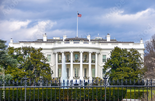 Washington DC, USA. White House view on cloudy day background and american flag.