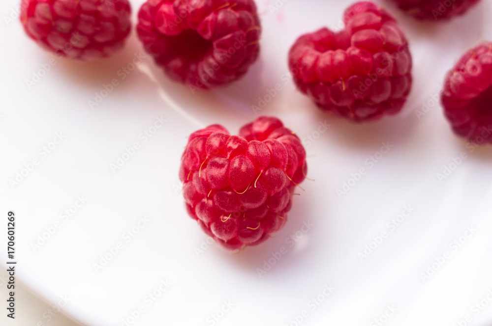 raspberries on a white saucer close up raspberries on a white saucer close up