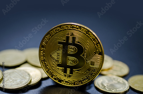 Photo of golden bitcoin (new virtual currency) with Gold coins.